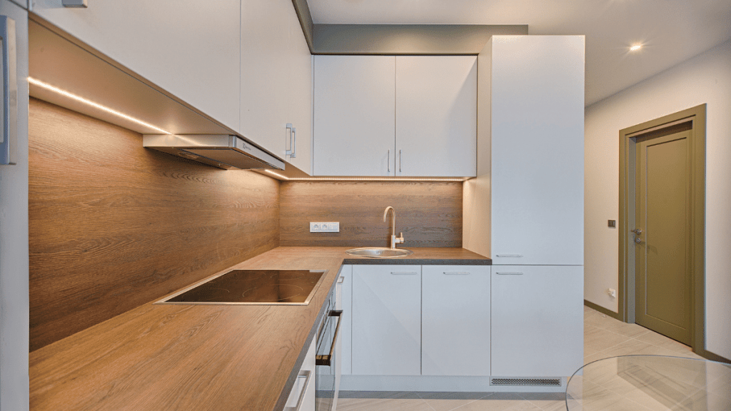 Modern kitchen with white kitchen cabinets and wooden countertops.