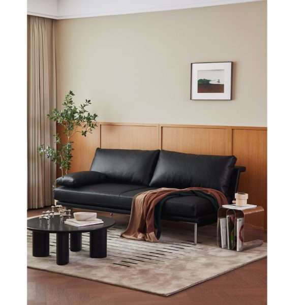 Black leather sofa styled with a round coffee table.