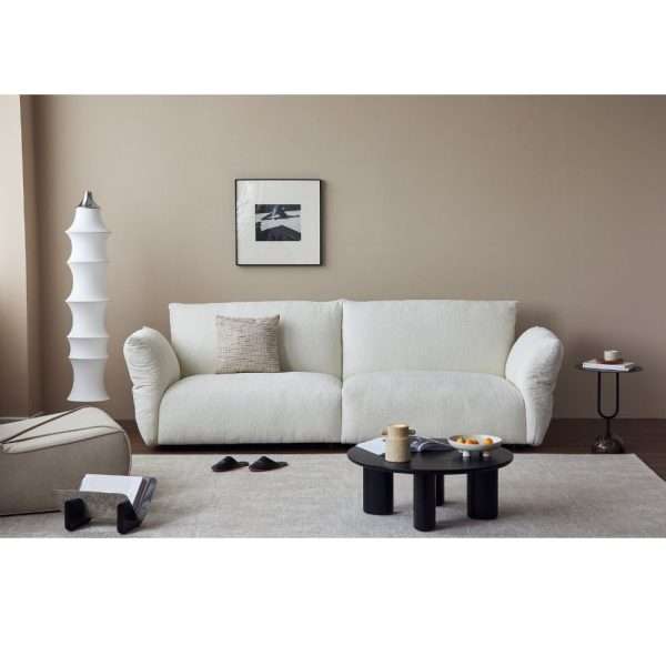 Modern white sofa in a cozy living room setting.