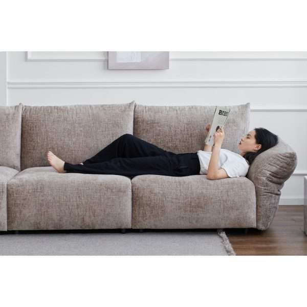 Modern sofa with a person relaxing and reading.